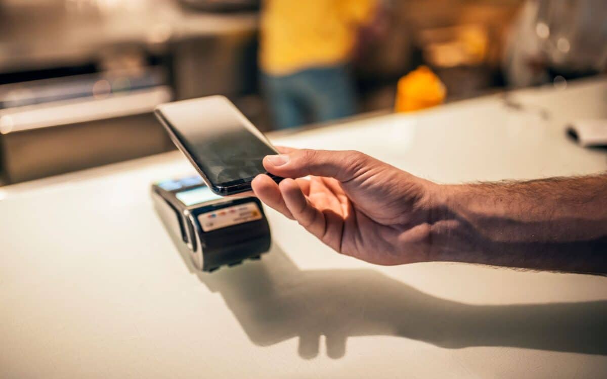 A customer uses a smartphone to complete a cashless banking transaction.
