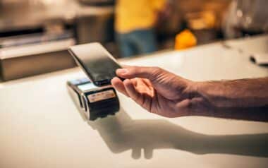 A customer uses a smartphone to complete a cashless banking transaction.