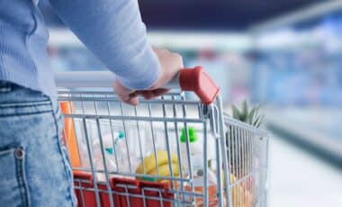 Man pushing shopping cart filled with groceries