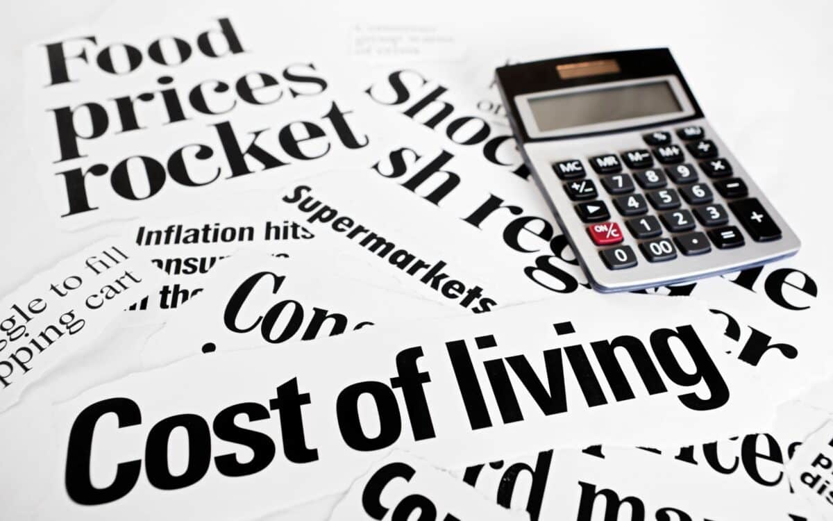 Calculator sits on headlines concerning rising cost of living