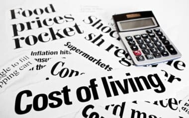 Calculator sits on headlines concerning rising cost of living