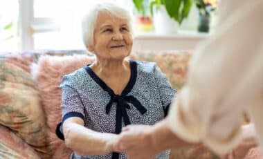 Elderly woman holding hands with younger woman
