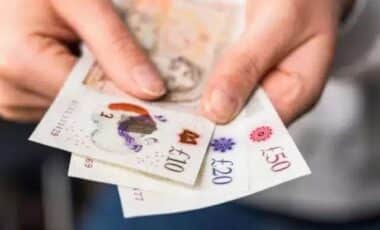 Hands Holding A Collection Of British Banknotes Including, £50, £20 And £10 Notes in Reference to DWP Update Confirms Pensioners Now Receiving £4,200 on Average with Pension Credit Top-Up