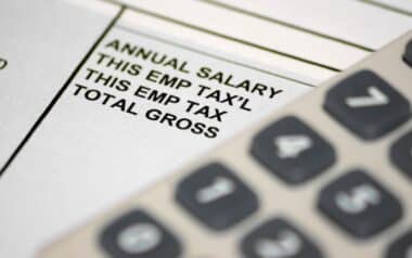 A pay slip underneath an out of focus calculator Civil Servants Pay Reform Could Reshape Public Sector Compensation