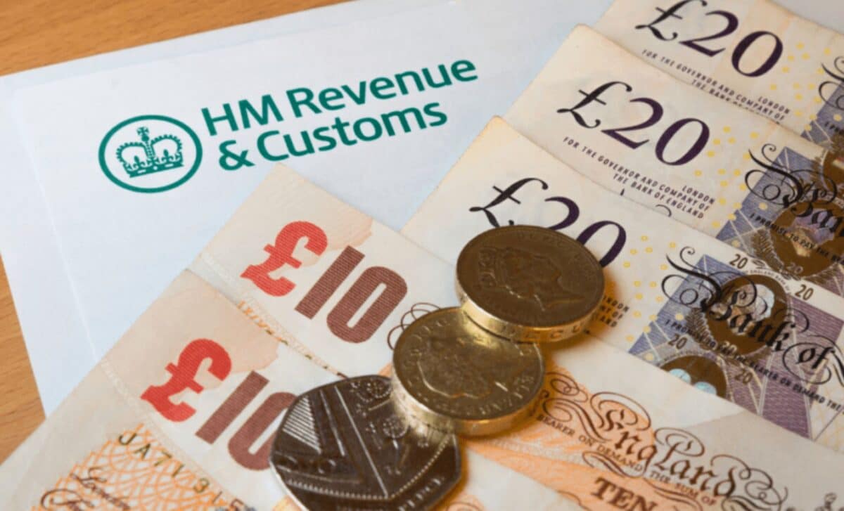 Close-up Document with HMRC Logo alongside British Currency Notes ( £10 and £20) and Some Coins