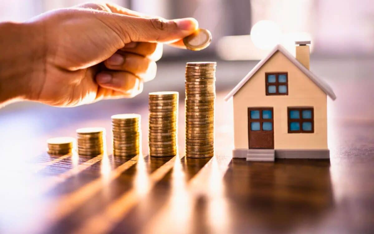 Homeowners-A hand placing a coin on top of a stack of coins, symbolizing growth