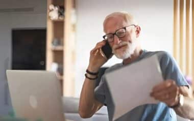 Pensioners-Elderly man reviewing documents while seeking assistance over the phone