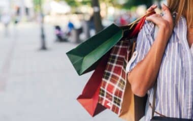 Retail-shopper carrying multiple brightly coloured shopping bags