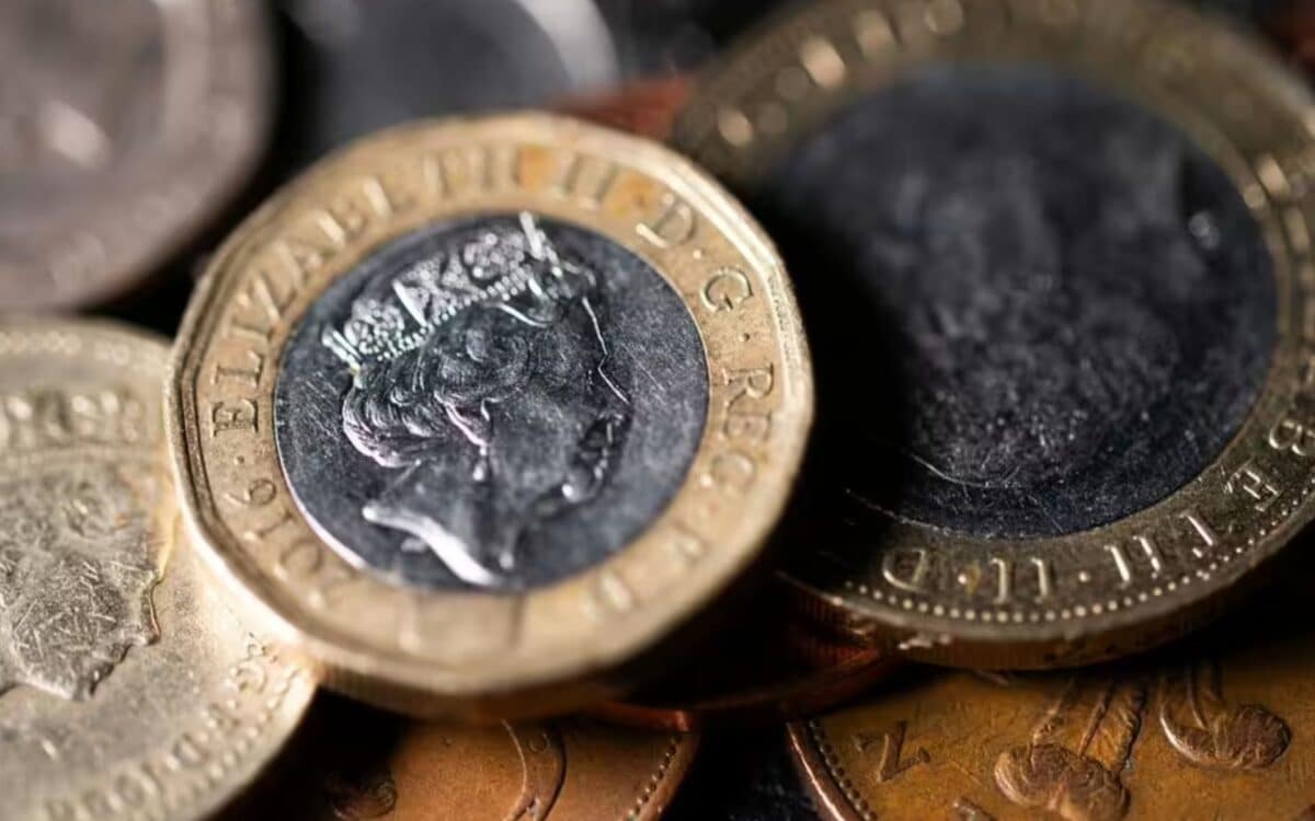 Benefit-close-up view of British pound coins, including a prominently displayed £1 coin featuring the profile of Queen Elizabeth