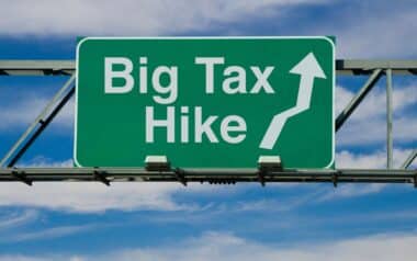 Businesses-Green highway-style sign with bold white text that reads Big Tax Hike.