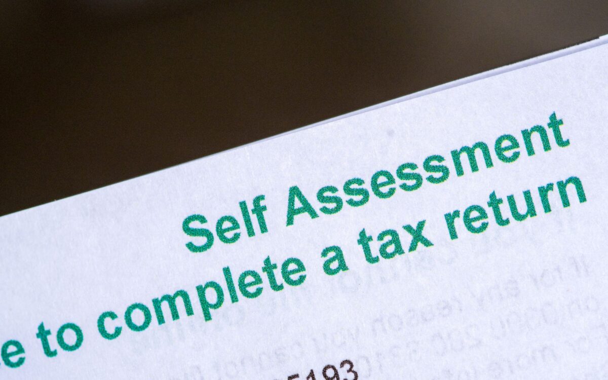 Close-up of a document with the bold text Self-Assessment prominently displayed at the top in green