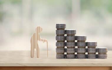 Retirement planning, Seniorman standing and stack of coins money