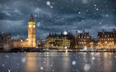 Snowfall-wintry scene in London, with snowflakes gently falling over the iconic Big Ben and the Houses of Parliament