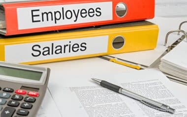 Workers-close-up of two colorful binders labeled Employees and Salaries, suggesting a focus on workforce management and compensation