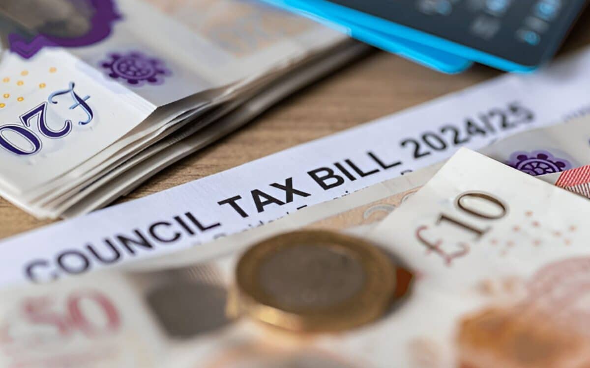 close-up view of a council tax bill for the year 202425, prominently displayed at the center. Surrounding the bill are various British banknotes