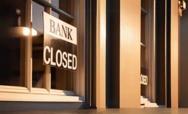 "BANK CLOSED" sign on the window of a bank, likely indicating closure for a bank holiday