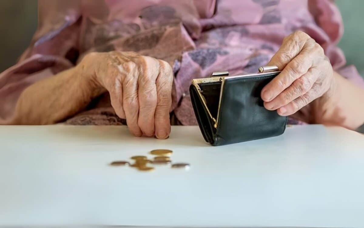 An elderly person's hands holding an open wallet