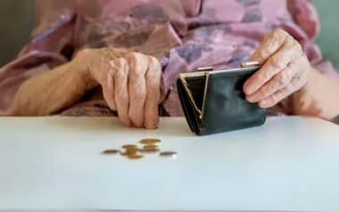 An elderly person's hands holding an open wallet