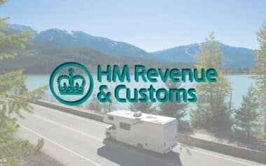 A motorhome drives by a lake and mountains, overlaid with the HMRC logo