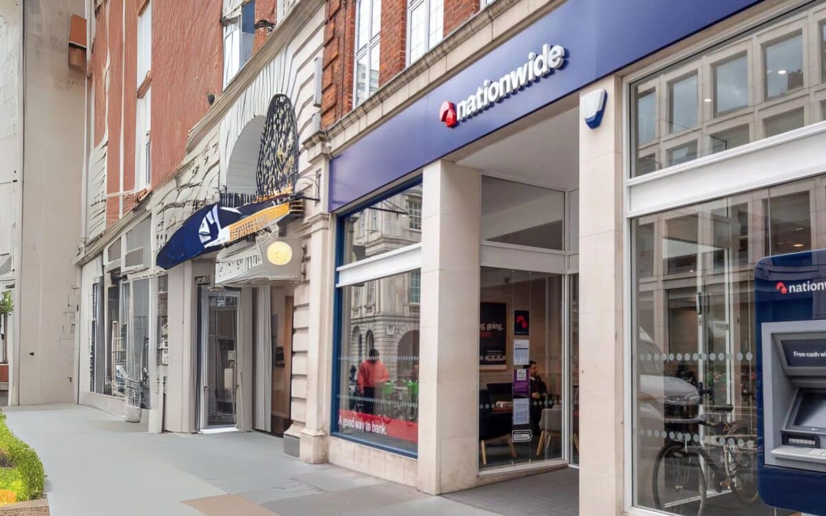 A Nationwide branch on a British high street, featuring a modern glass frontage and an ATM outside the building.
