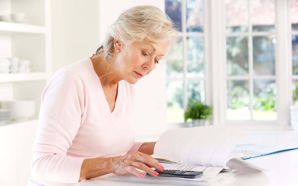 An older woman calculating her finances.