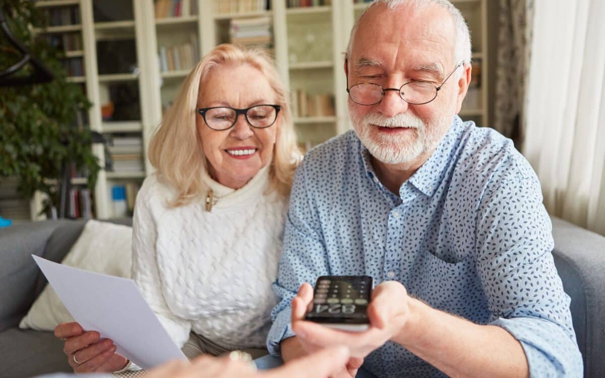 Two pensioners sit and go over documents.