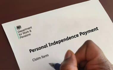 A person holding a pen prepares to fill out a PIP
