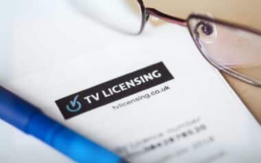 Close-up of an official TV Licensing letter, with reading glasses and a pen in the background.