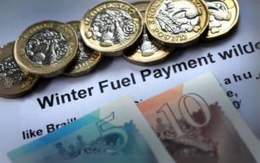 British currency arranged on top of a document Winter Fuel Payment.