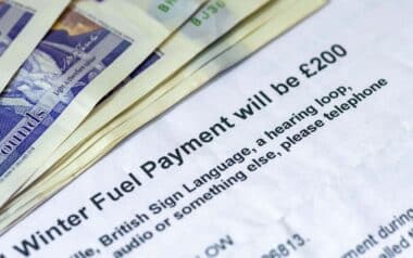 A UK government letter showing details about Winter Fuel Payments, alongside several £20 banknotes,