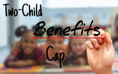 A hand underlining the words "Two-Child Benefits Cap"