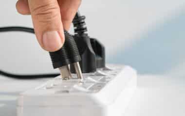 Close up of Hand Plugging into Electrical Outlet