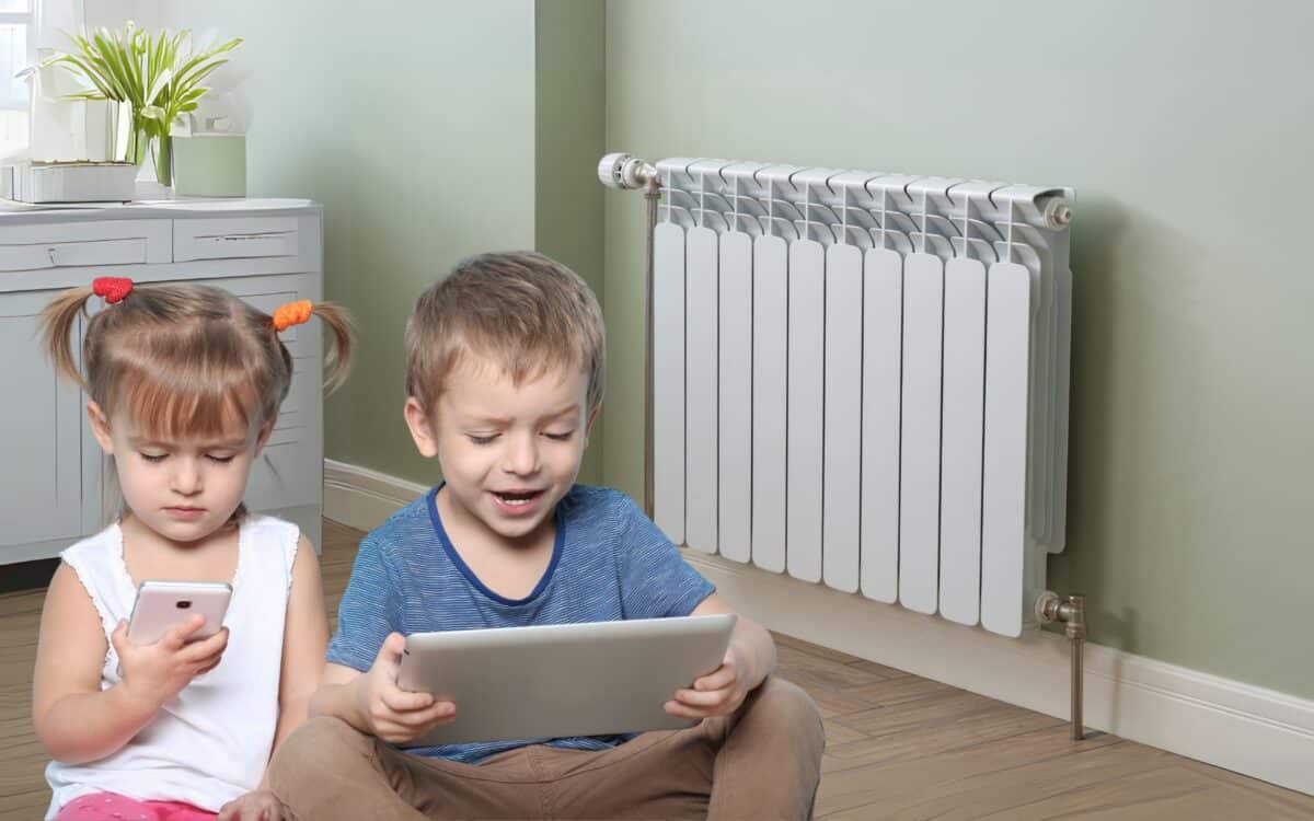 Heating Radiator and Children with Tablet, Phone