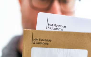 Mid adult man opening HMRC tax letter