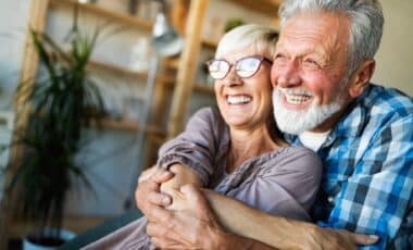 Two retirees hugging and smiling