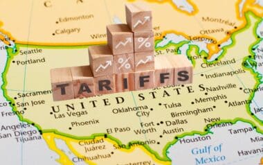 wooden blocks spelling out "tariffs" placed over a map of the United States