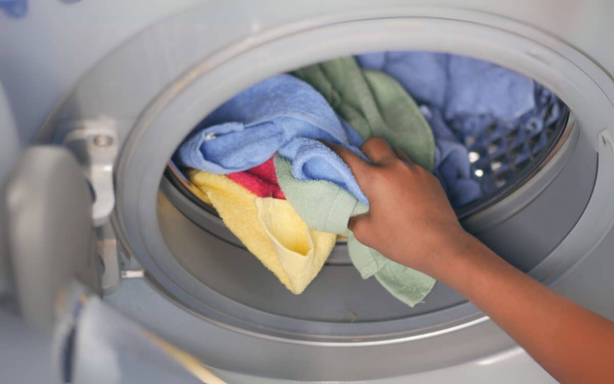 Woman Hand Putting Towels in Washing Machine