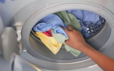 Woman Hand Putting Towels in Washing Machine