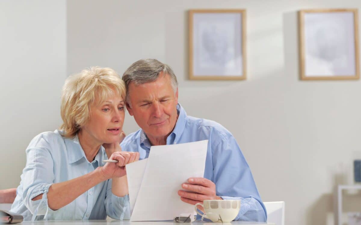 Seniors reading paperwork for Pension Credit checks.