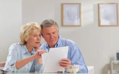 Seniors reading paperwork for Pension Credit checks.