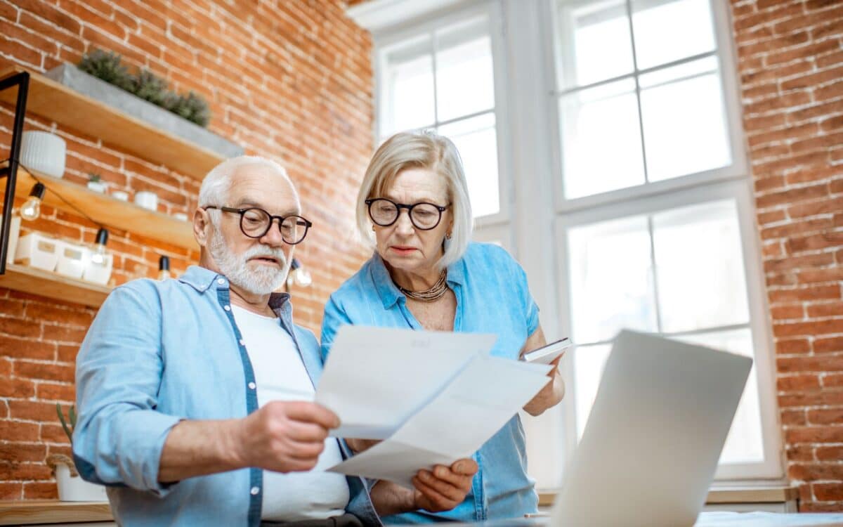 Senior Couple with Documents and Laptop at Home