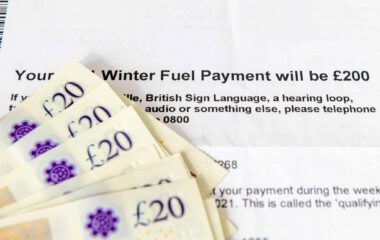 A close-up of a document detailing a Winter Fuel Payment of £200, with £20 banknotes placed in front of it