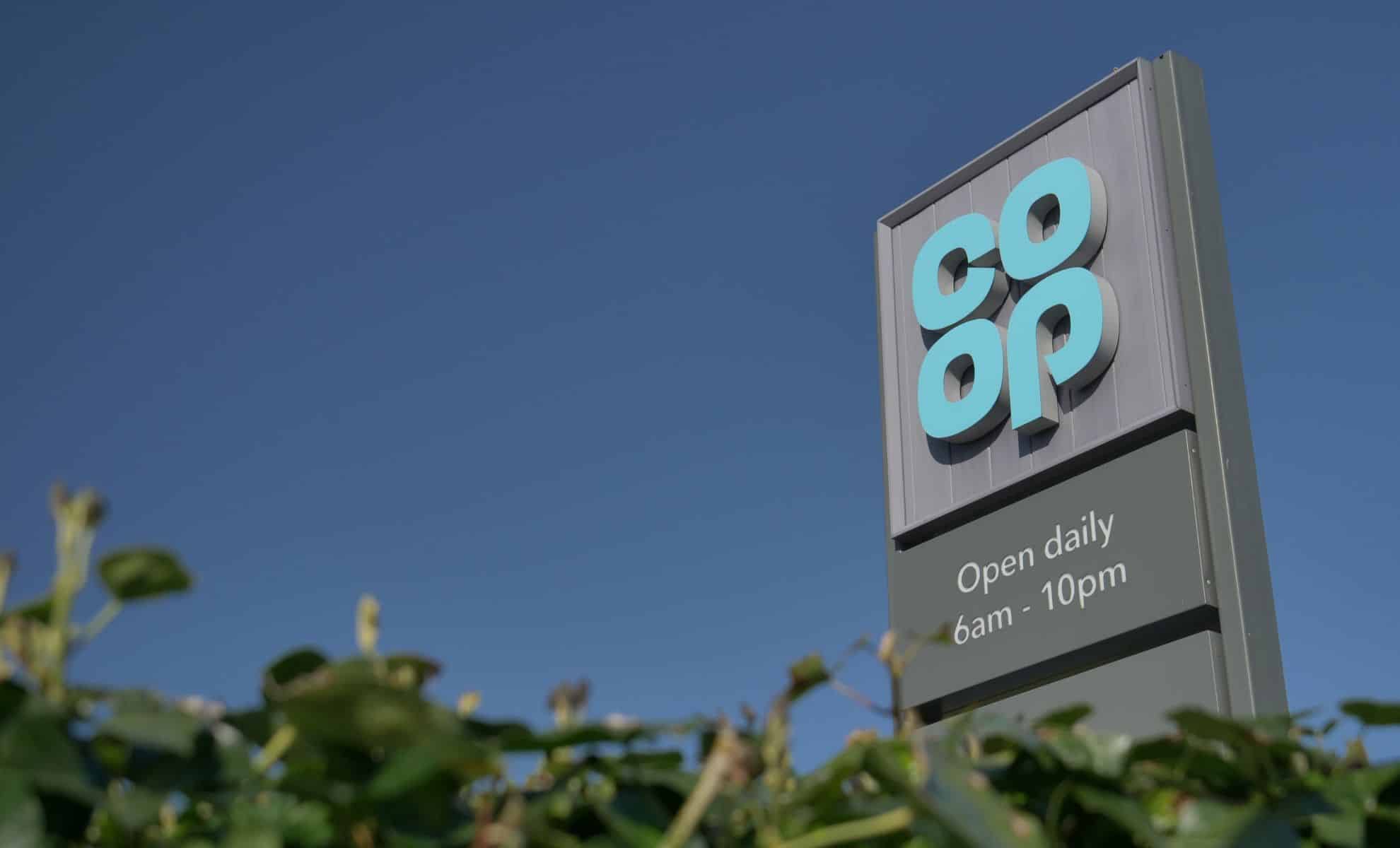 Co-op sign with logo and opening hours.