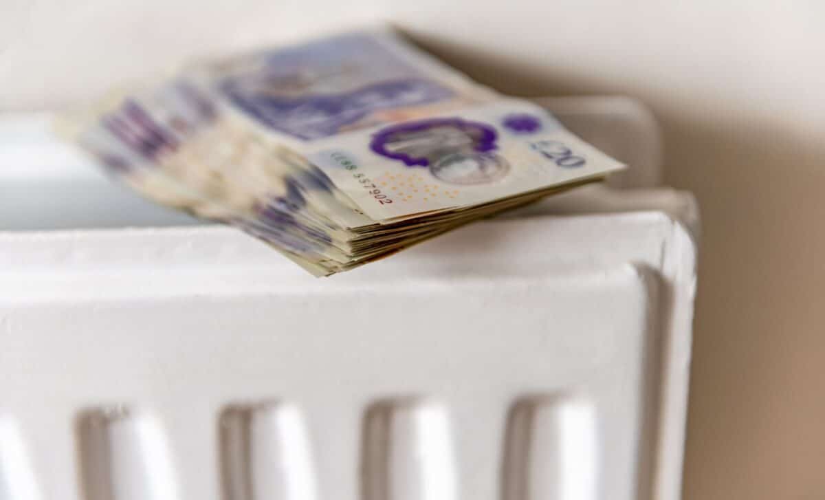 Stack of banknotes, specifically £20 notes, resting on a white radiator.