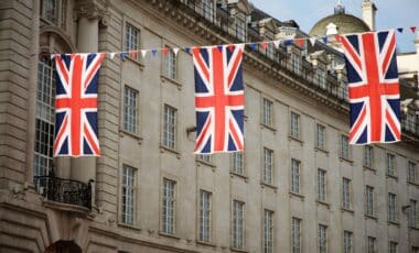Union Jack Flags Strung In Front Of A Building to refer to UK Could See Extra Bank Holiday in 2025 with Plans for a Four-Day Weekend