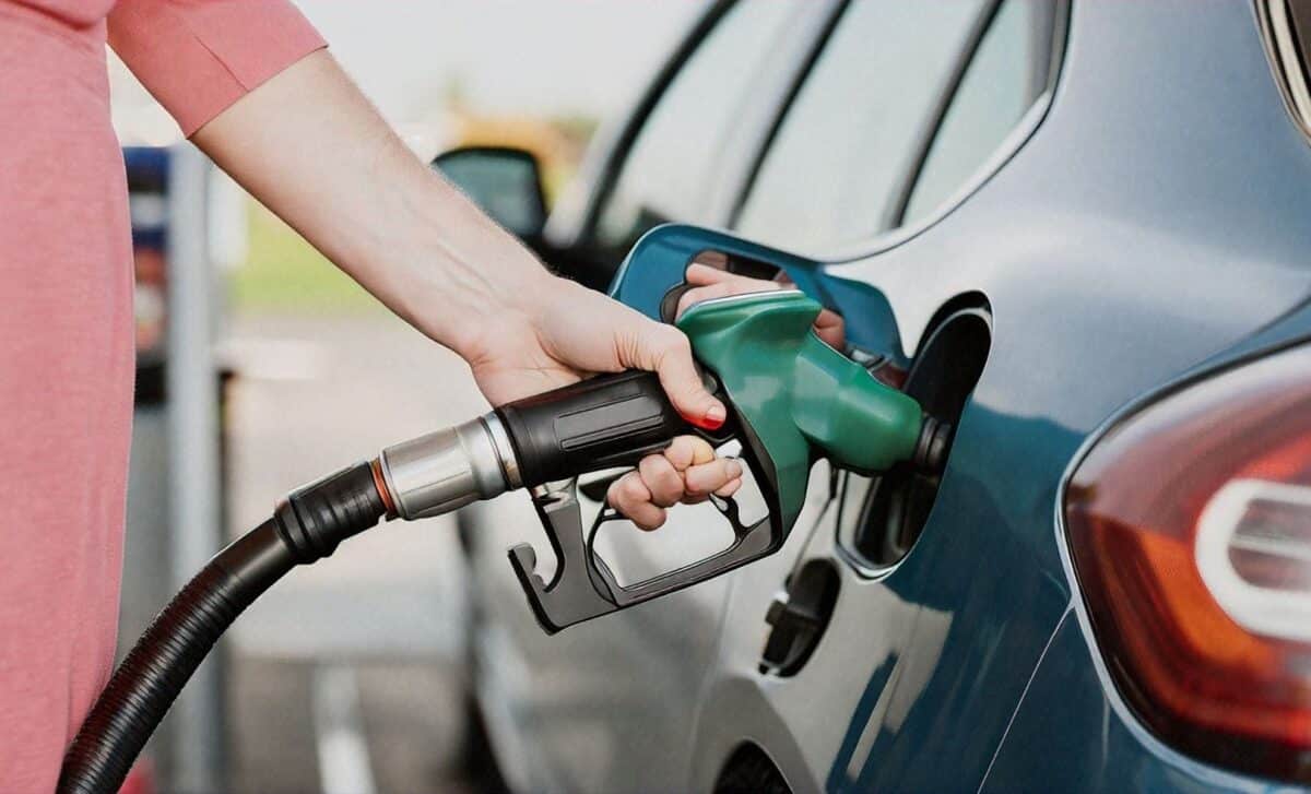 Close up of hand filling up car with fuel at a UK fuel station.