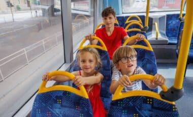 Three children are sitting on a bus.