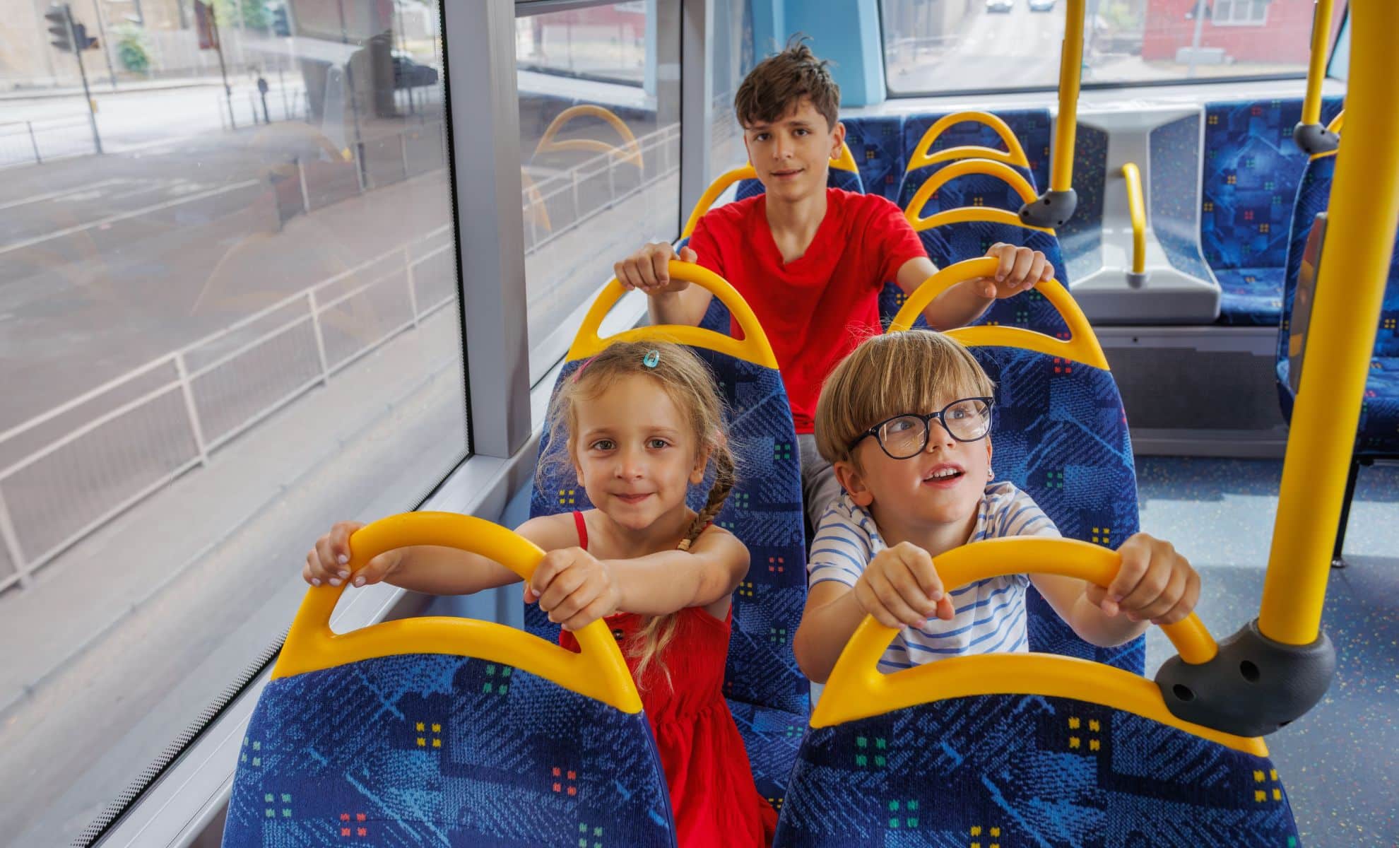 Three children are sitting on a bus.