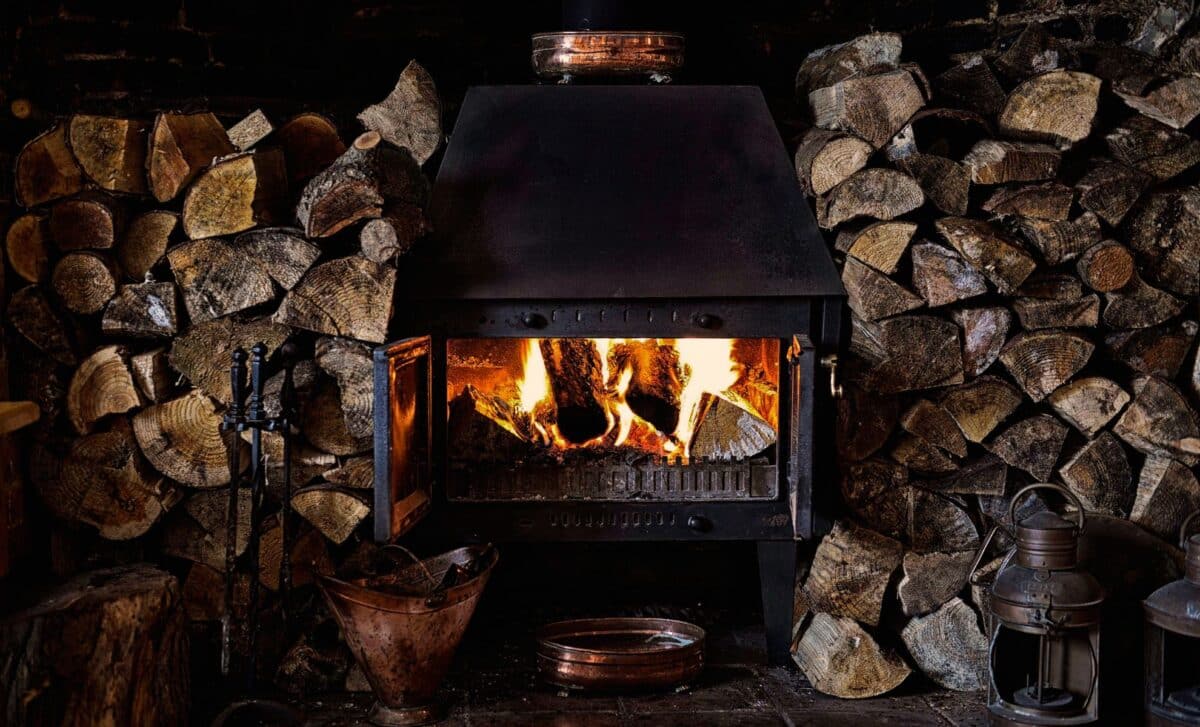 Rustic Wood Burner alight and surrounded by cut logs