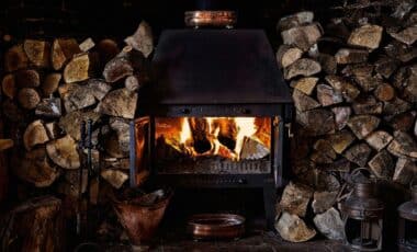Rustic Wood Burner alight and surrounded by cut logs